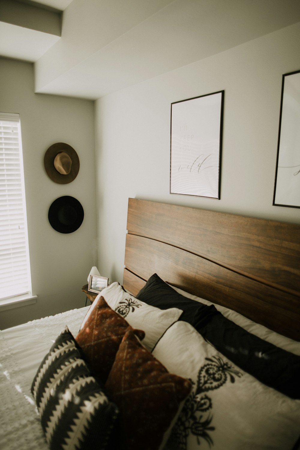 black wooden bed frame with white and black bed pillow