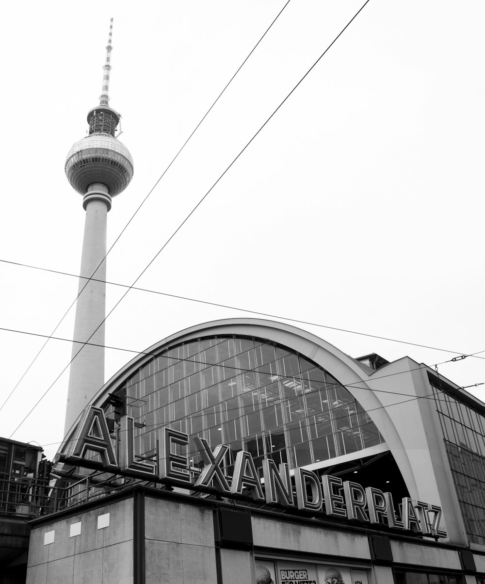 a black and white photo of a building with a television tower in the background
