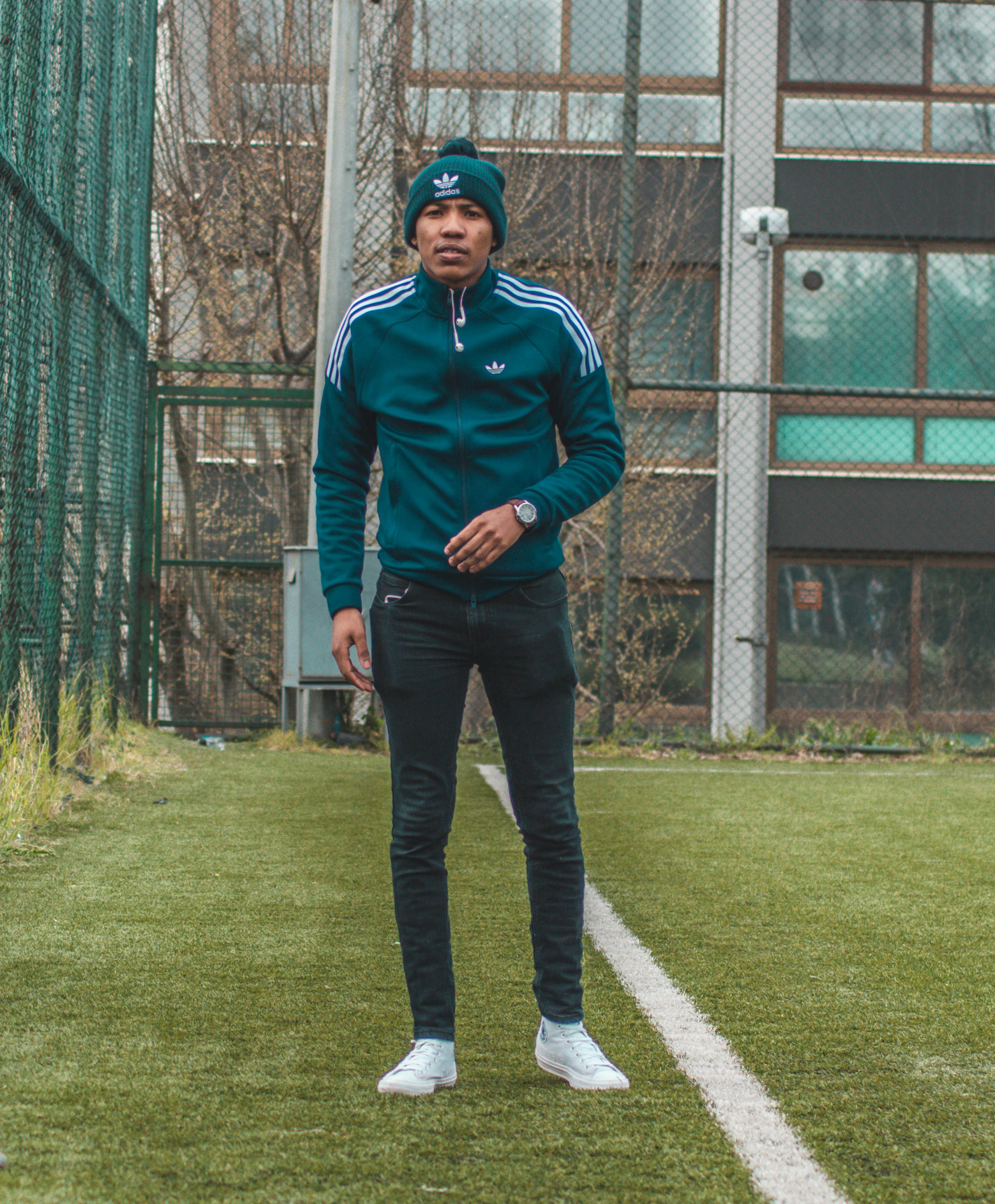 man in blue zip up jacket standing on green grass field during daytime