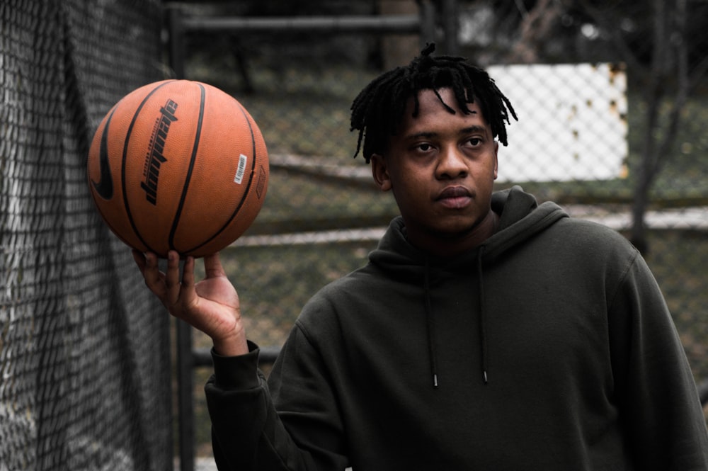 man in gray hoodie holding basketball