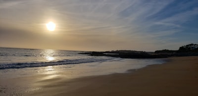 sea waves crashing on shore during sunset