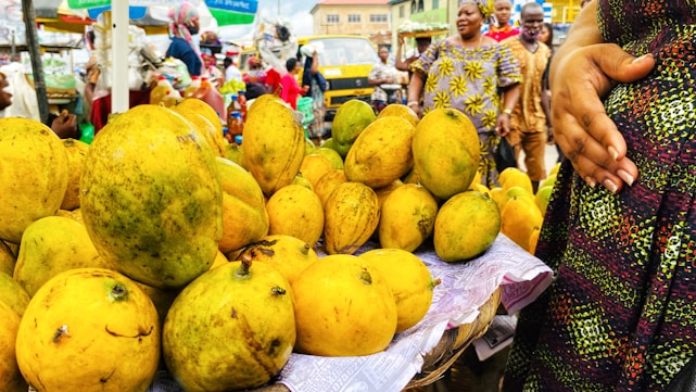 A vibrant marketplace scene with fresh mangoes and bananas stacked in rustic baskets