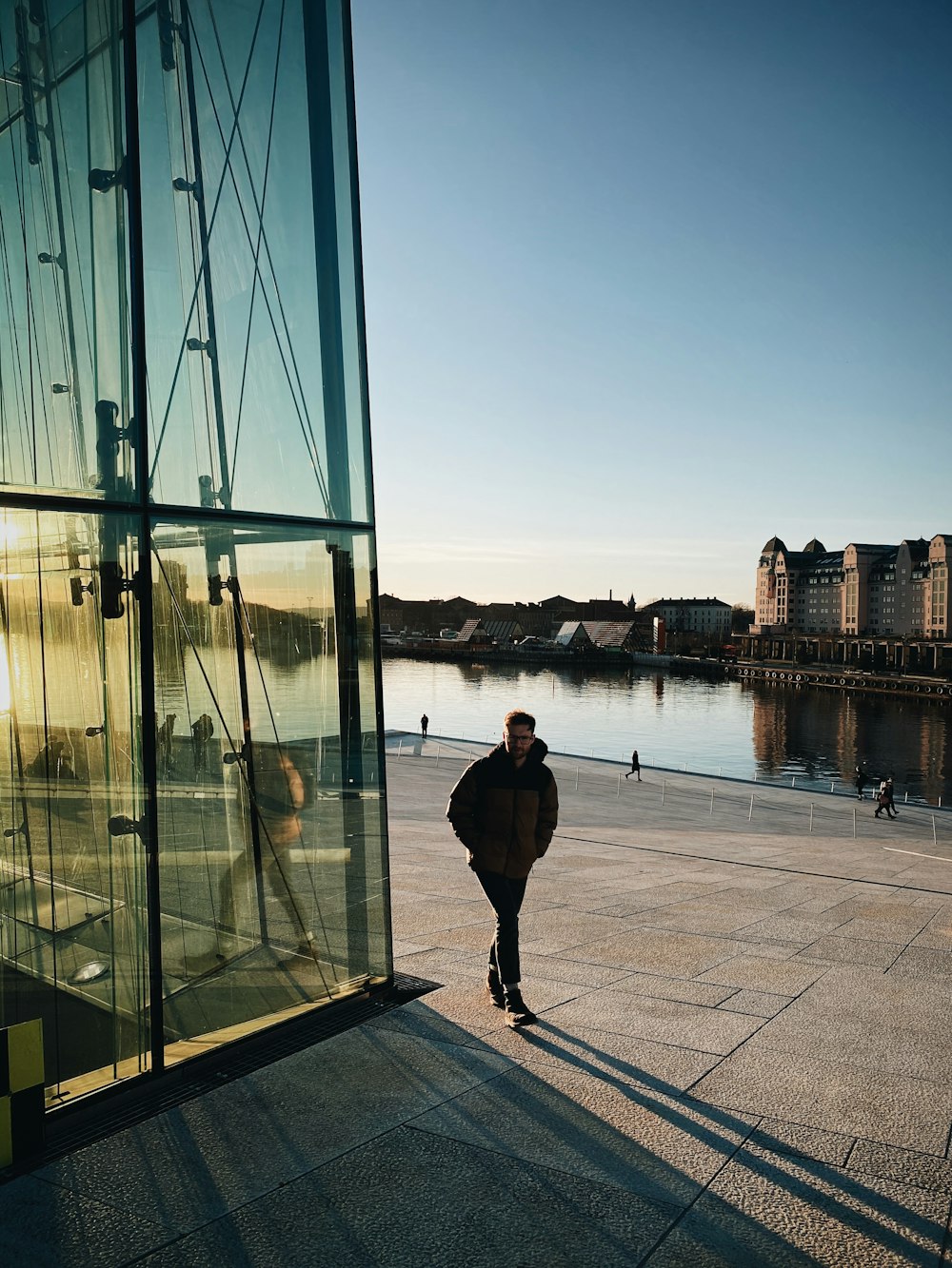 man in black jacket and pants standing on dock during daytime