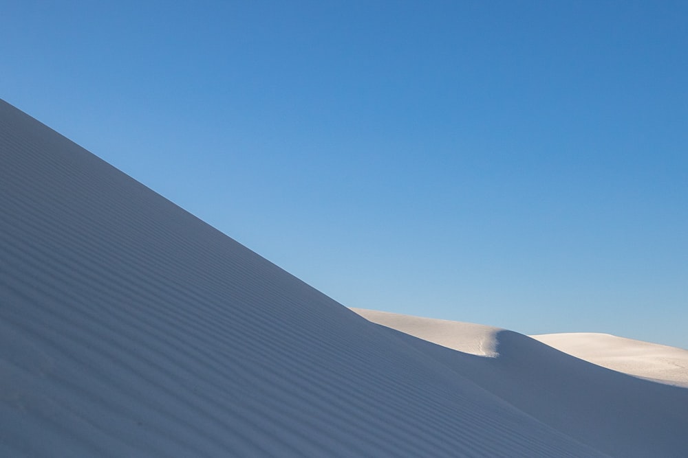sabbia bianca sotto il cielo blu durante il giorno
