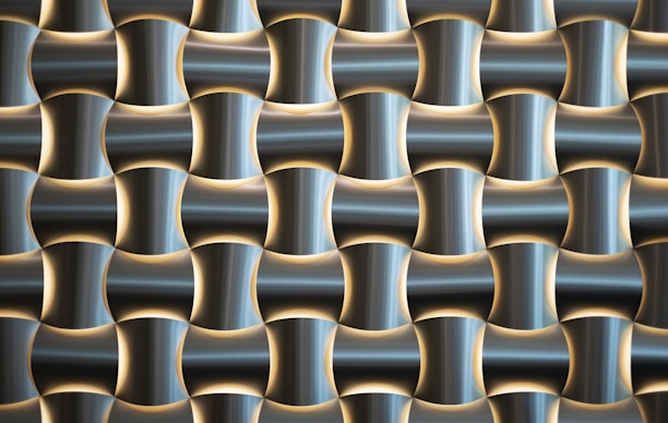 A pattern of interlocking, three-dimensional metallic shapes with a glossy finish. The design creates a sense of depth through the alternating concave and convex forms, which are accented by soft lighting highlighting the contours.