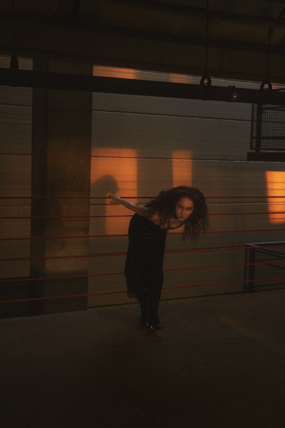 woman in black jacket standing near brown brick wall