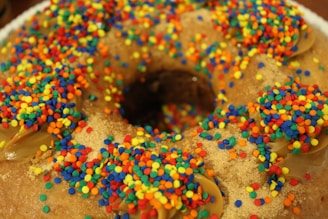 Close-up of a pastel-colored mochi donut with a glossy glaze and sprinkles.
