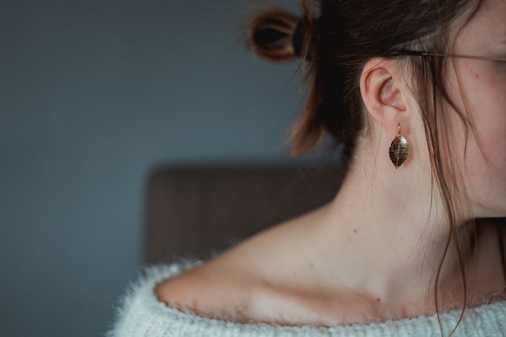 woman in white knit shirt wearing silver stud earring