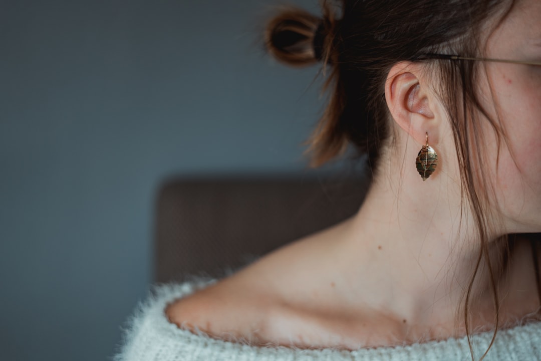 woman in white knit shirt wearing silver stud earring