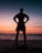 silhouette of man standing on beach during sunset