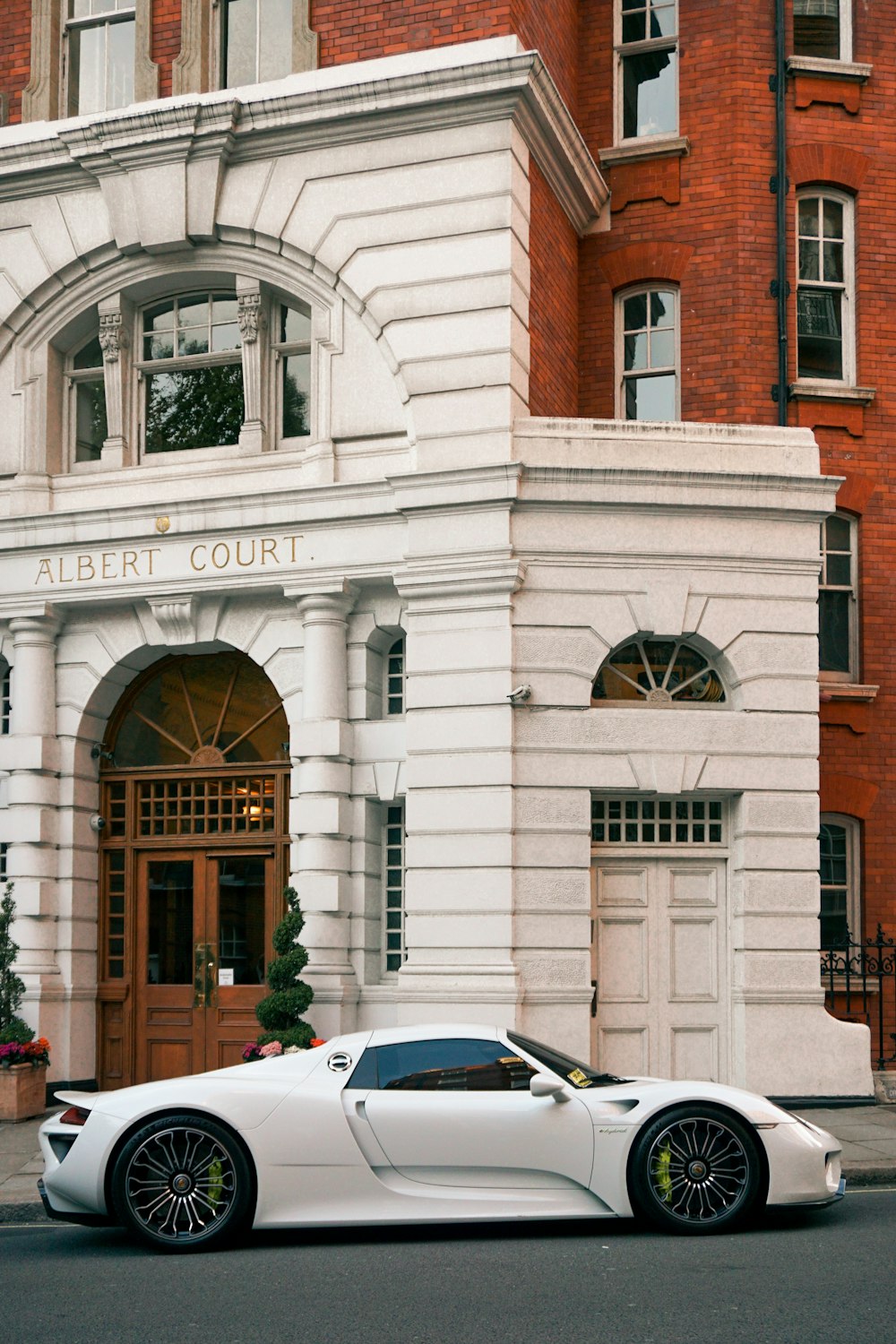 white car parked in front of brown and white concrete building