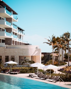 white concrete building near palm trees during daytime