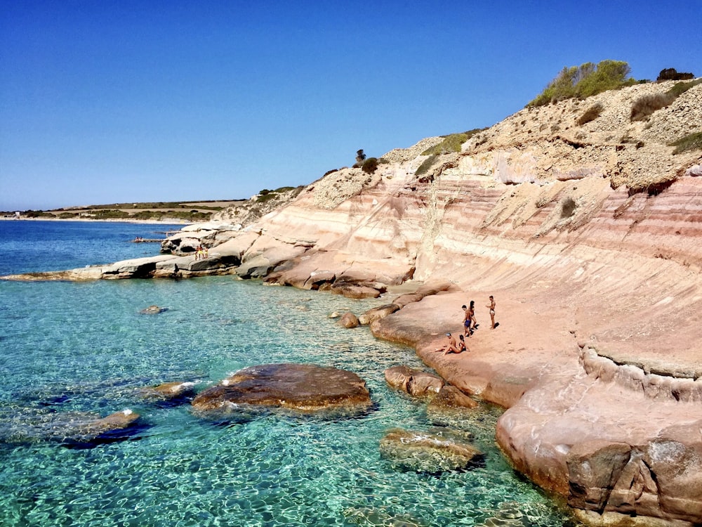 brown rock formation near body of water during daytime