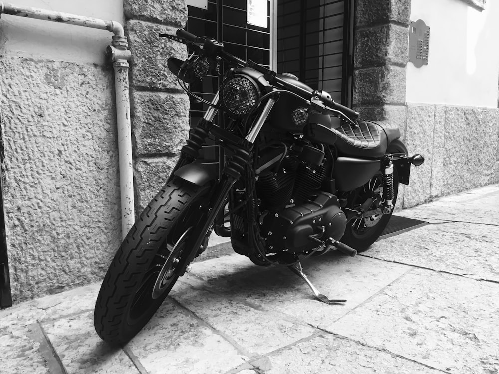 black motorcycle parked beside wall