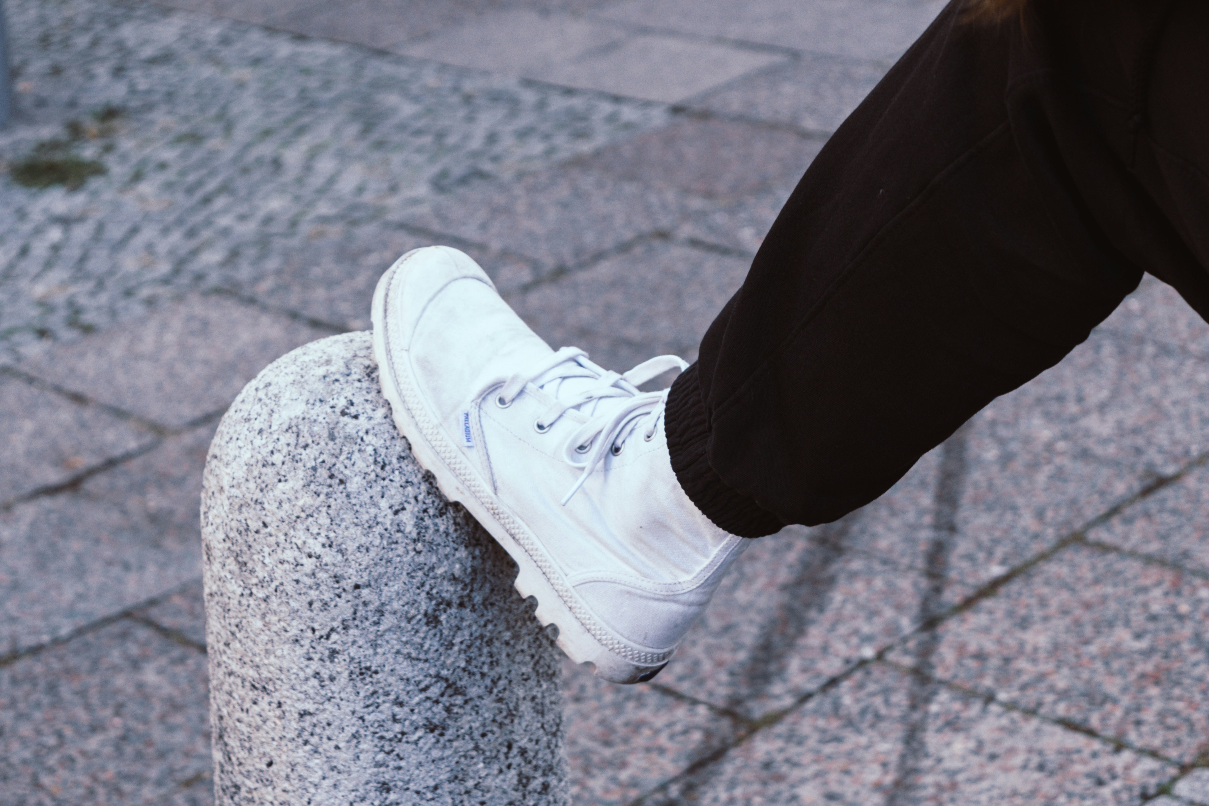 person in black pants and white sneakers