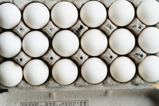 Carton of large white eggs stacked on a delivery truck bed.