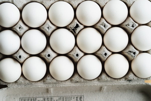 Carton of large white eggs stacked on a delivery truck bed.