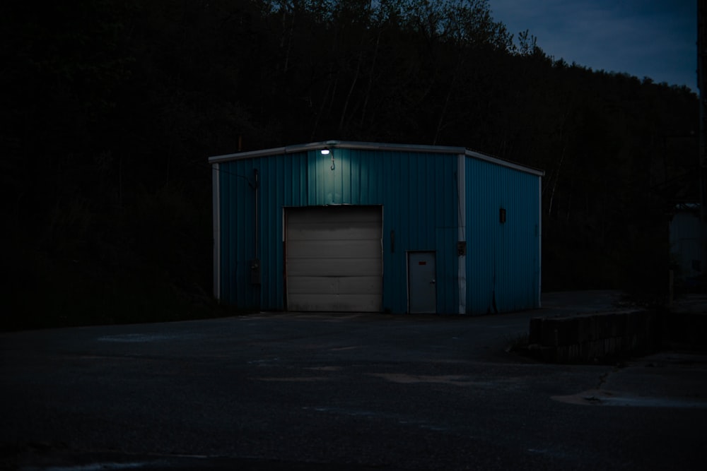 white and blue wooden house near trees during night time