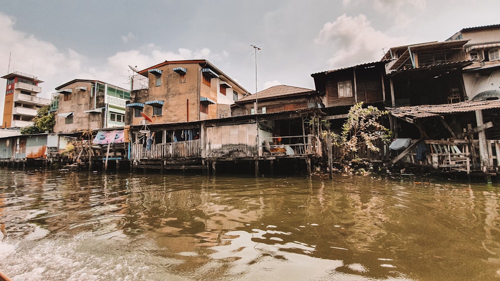 edifício de concreto marrom e branco ao lado do corpo de água durante o dia