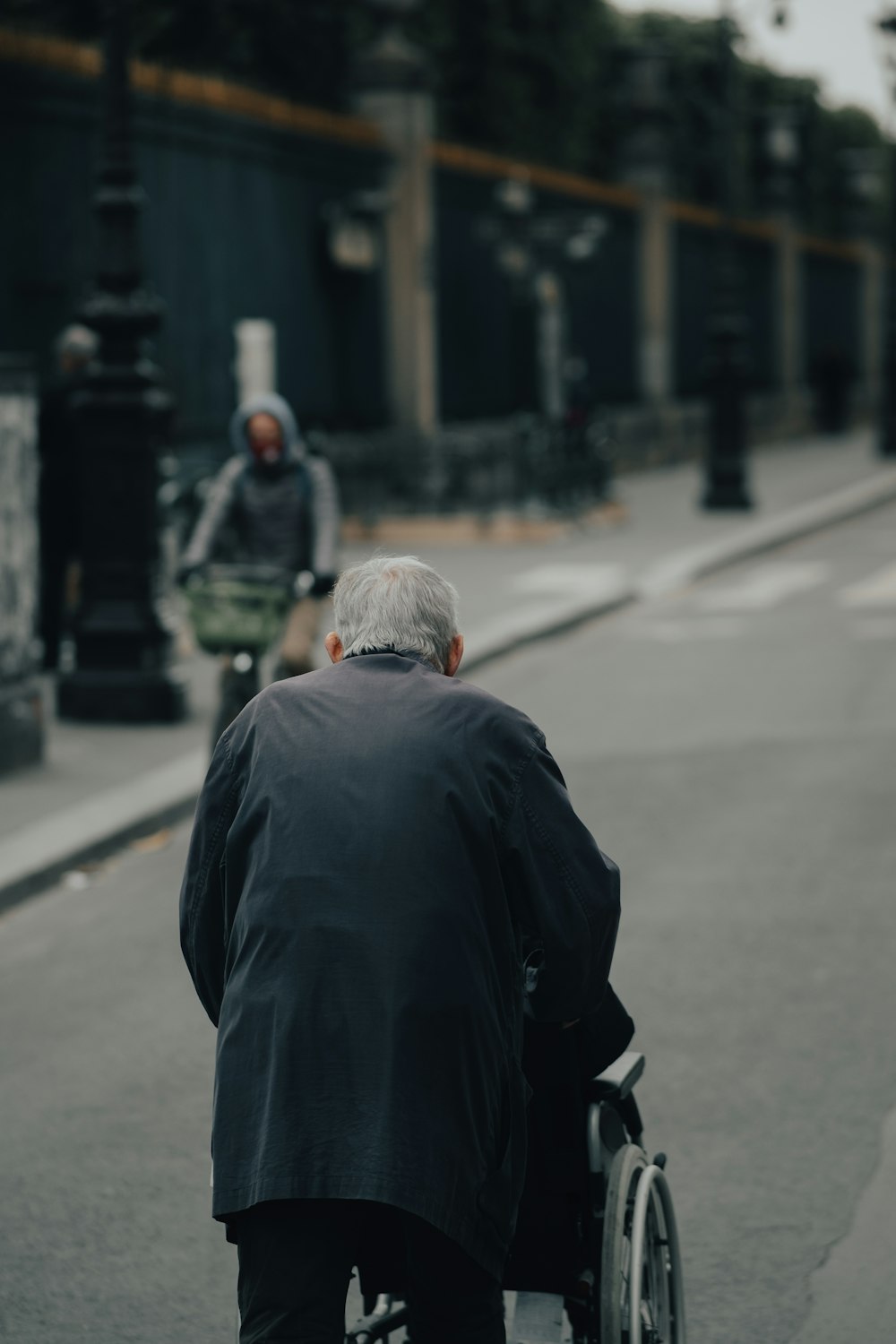 낮 동안 도로에 서 있는 검은 재킷을 입은 남자