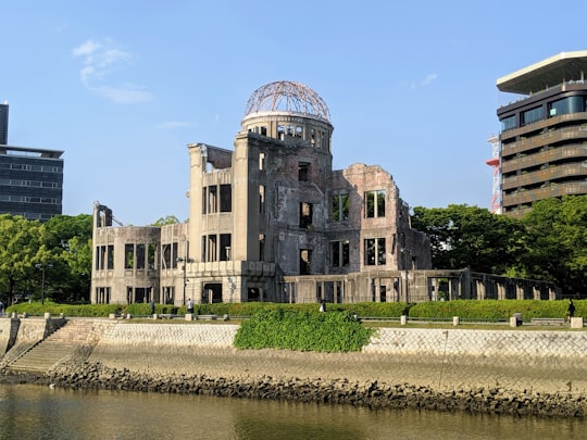 brown concrete building near body of water during daytime in Atomic Bomb Dome Japan