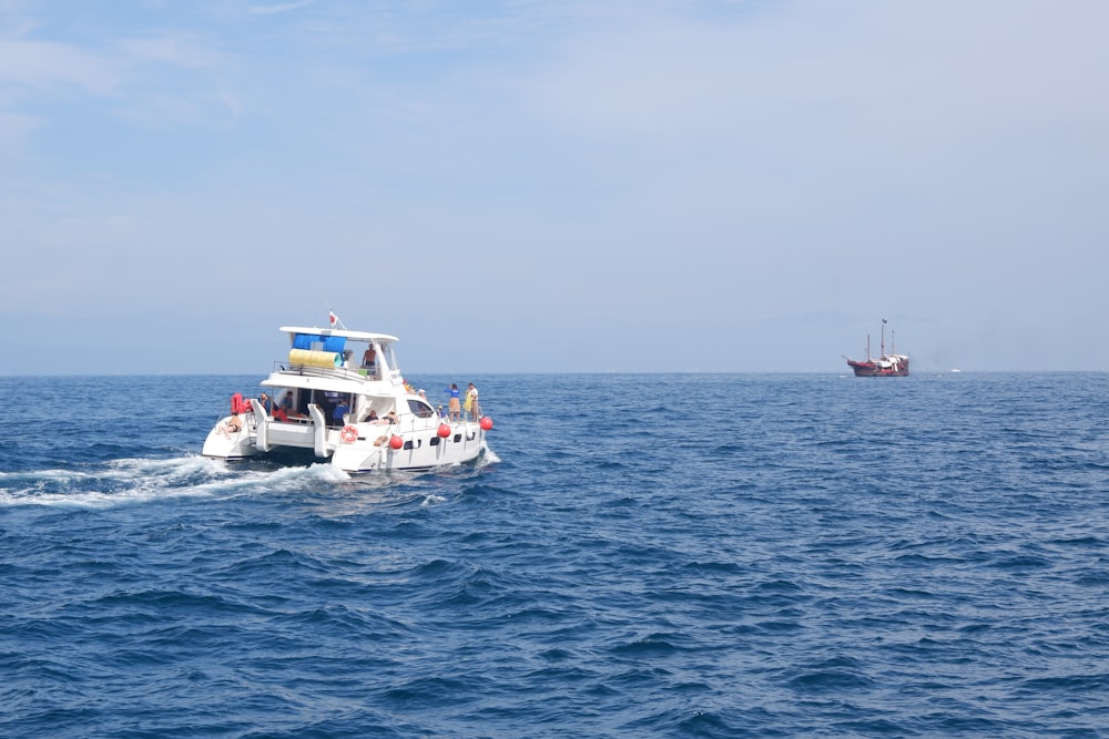 barco branco e vermelho no mar sob o céu branco durante o dia