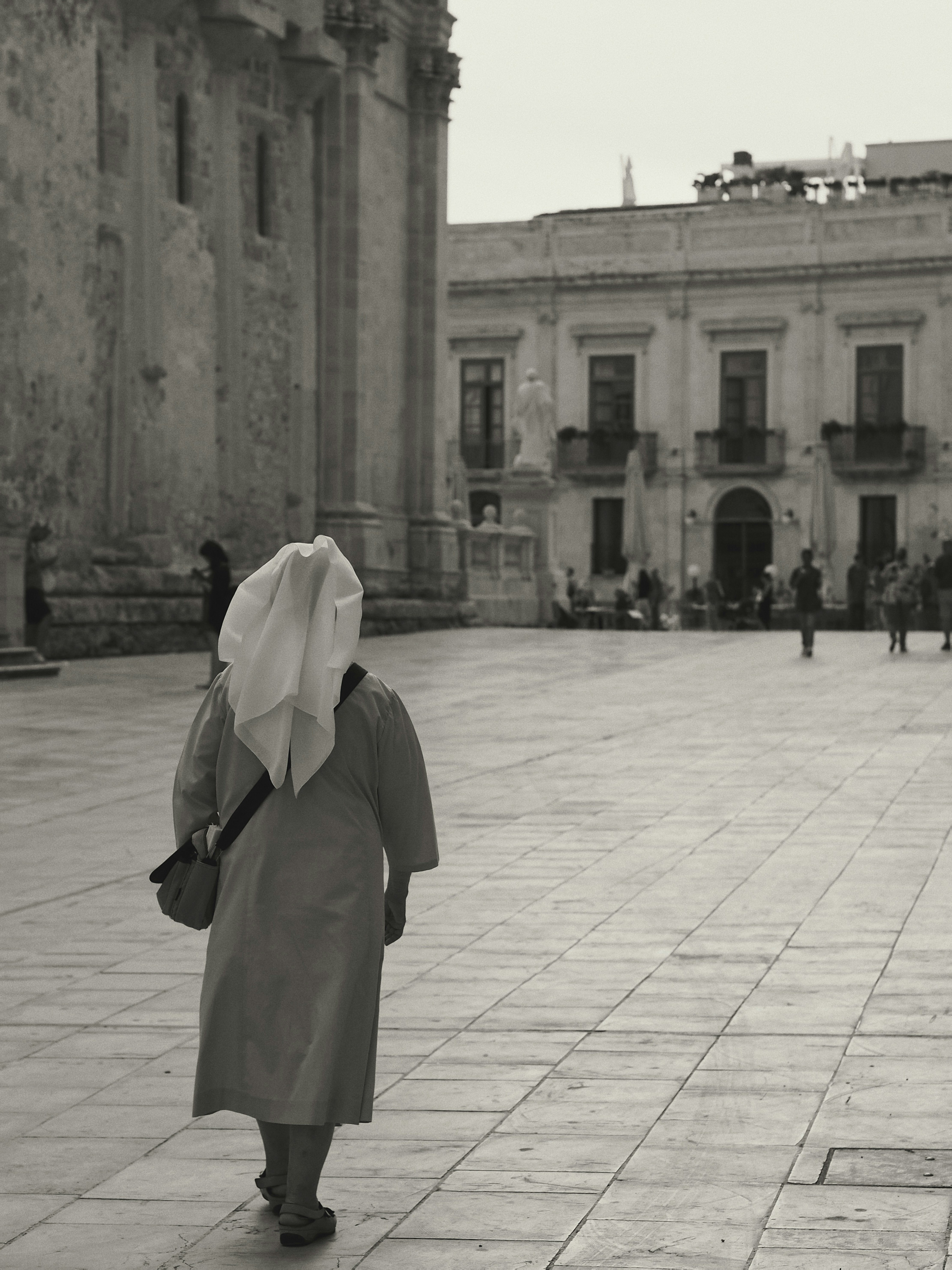 Grayscale photo of woman in white hijab standing on sidewalk photo ...