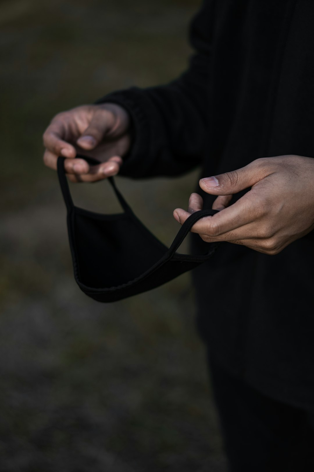 person holding black brassiere during daytime