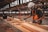man in orange and black vest wearing white helmet holding yellow and black power tool