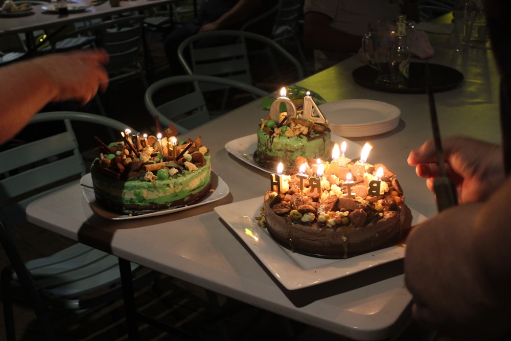 brown and green cake with candles on white table