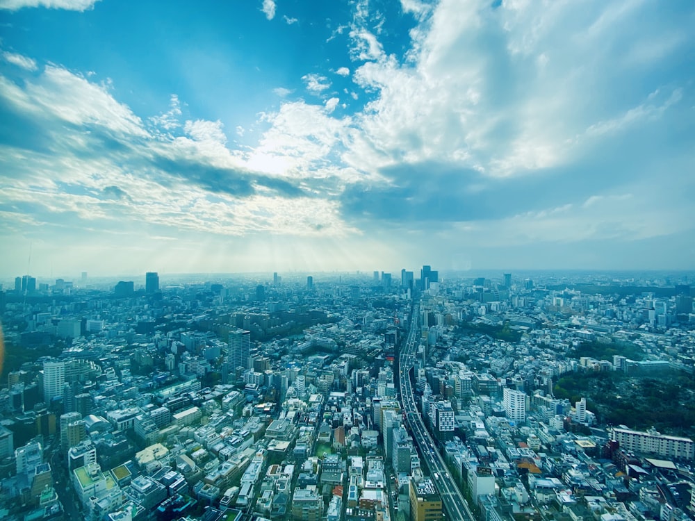 city buildings under blue sky and white clouds during daytime