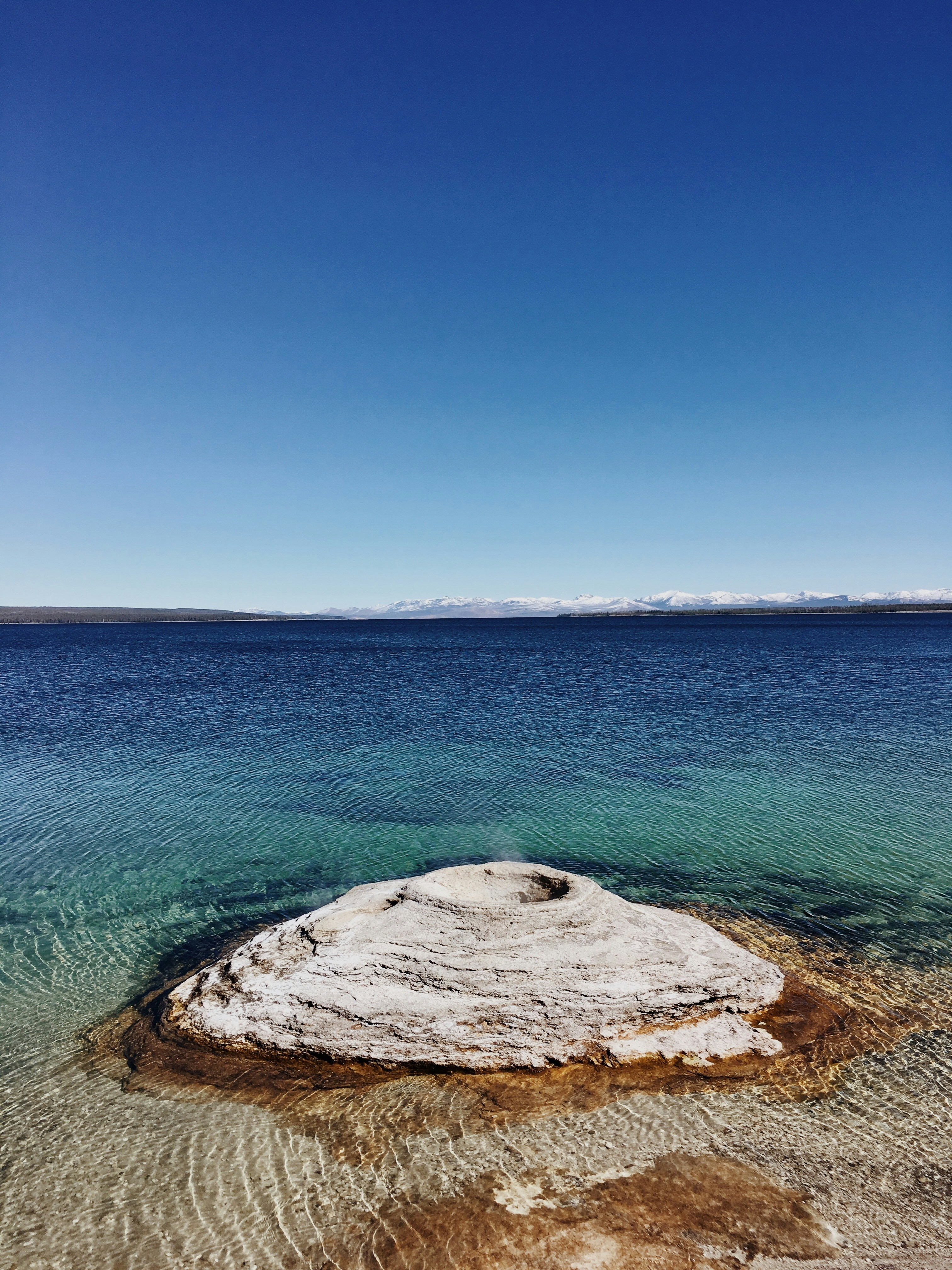 a large rock in the middle of a body of water