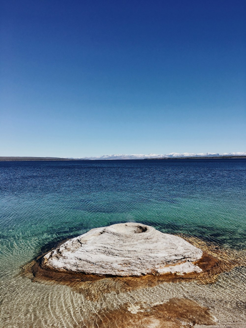 a large rock in the middle of a body of water