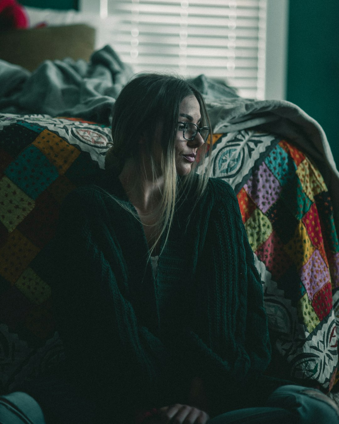 woman in black jacket sitting on bed