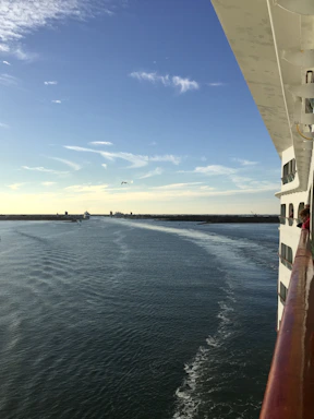 Ron Lemaster smiling aboard a cruise ship deck with the ocean stretching behind him under a clear blue sky.