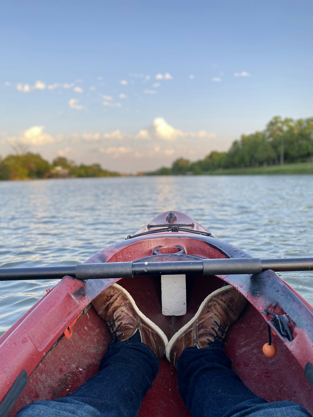 person in red kayak on body of water during daytime