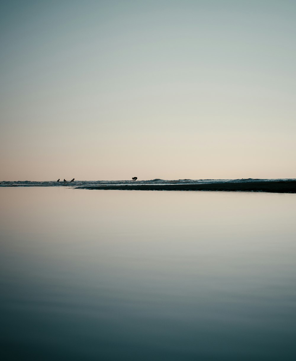 a large body of water sitting under a blue sky