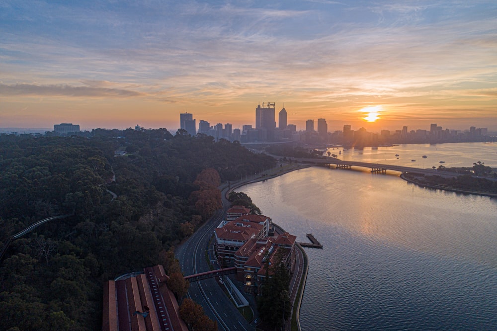 the sun is setting over a city and a river