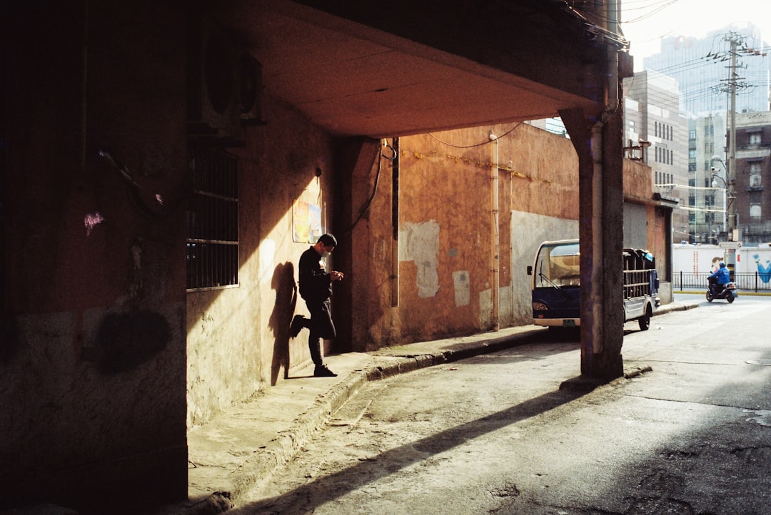 man in black jacket walking on sidewalk during daytime