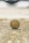 A Filipino ten peso coin is standing on its edge on a textured surface. The background is blurred, focusing the attention on the coin which features the inscription 'Republika ng Pilipinas' and portraits of two individuals.