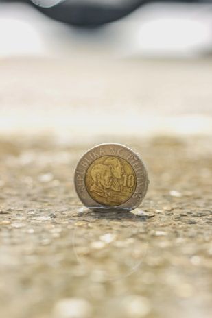 Philippine peso bills and coins spread out on a wooden table, symbolizing financial support.