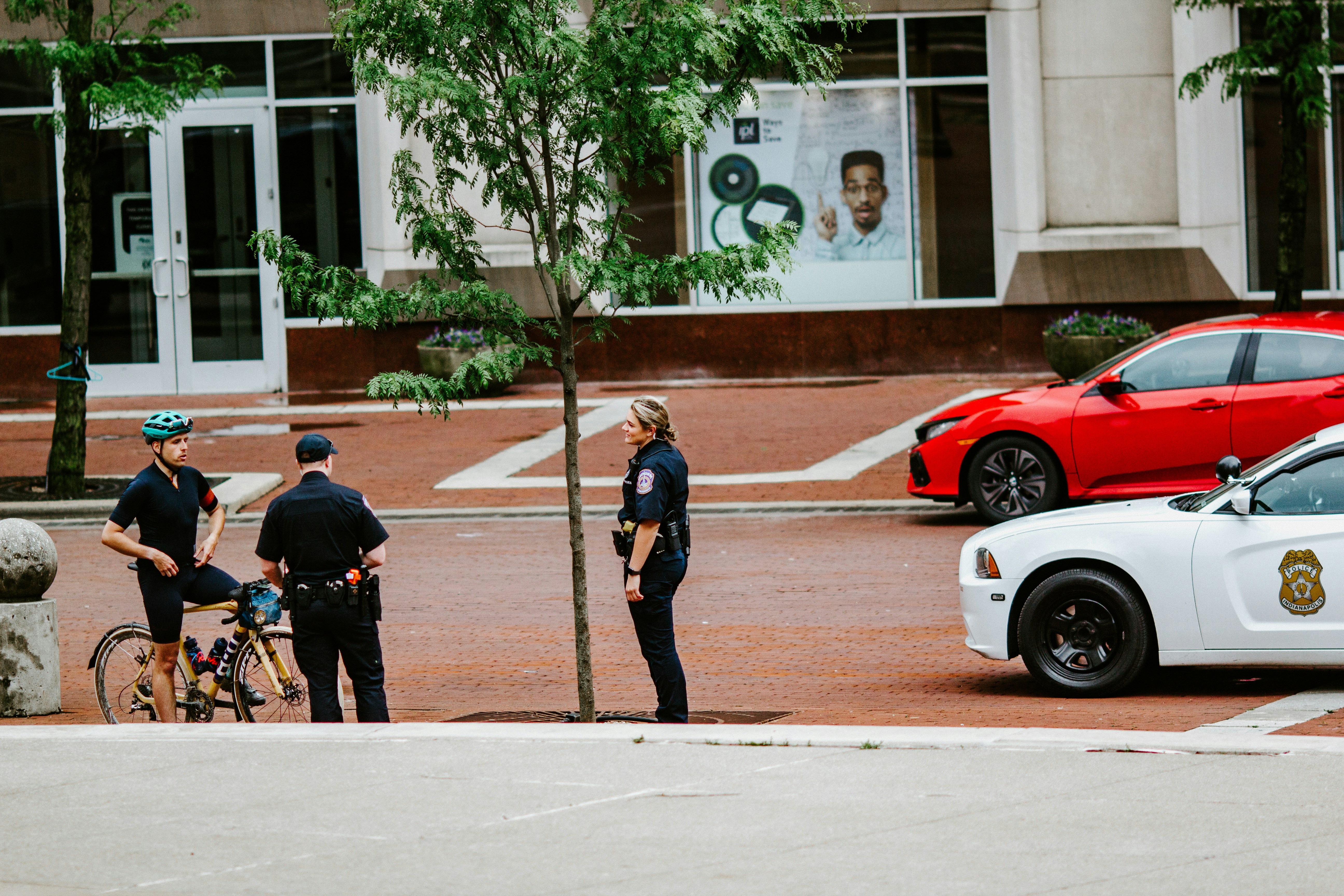 man in black jacket and black pants standing beside red and white car during daytime (Photo by Gabe Pierce on Unsplash)