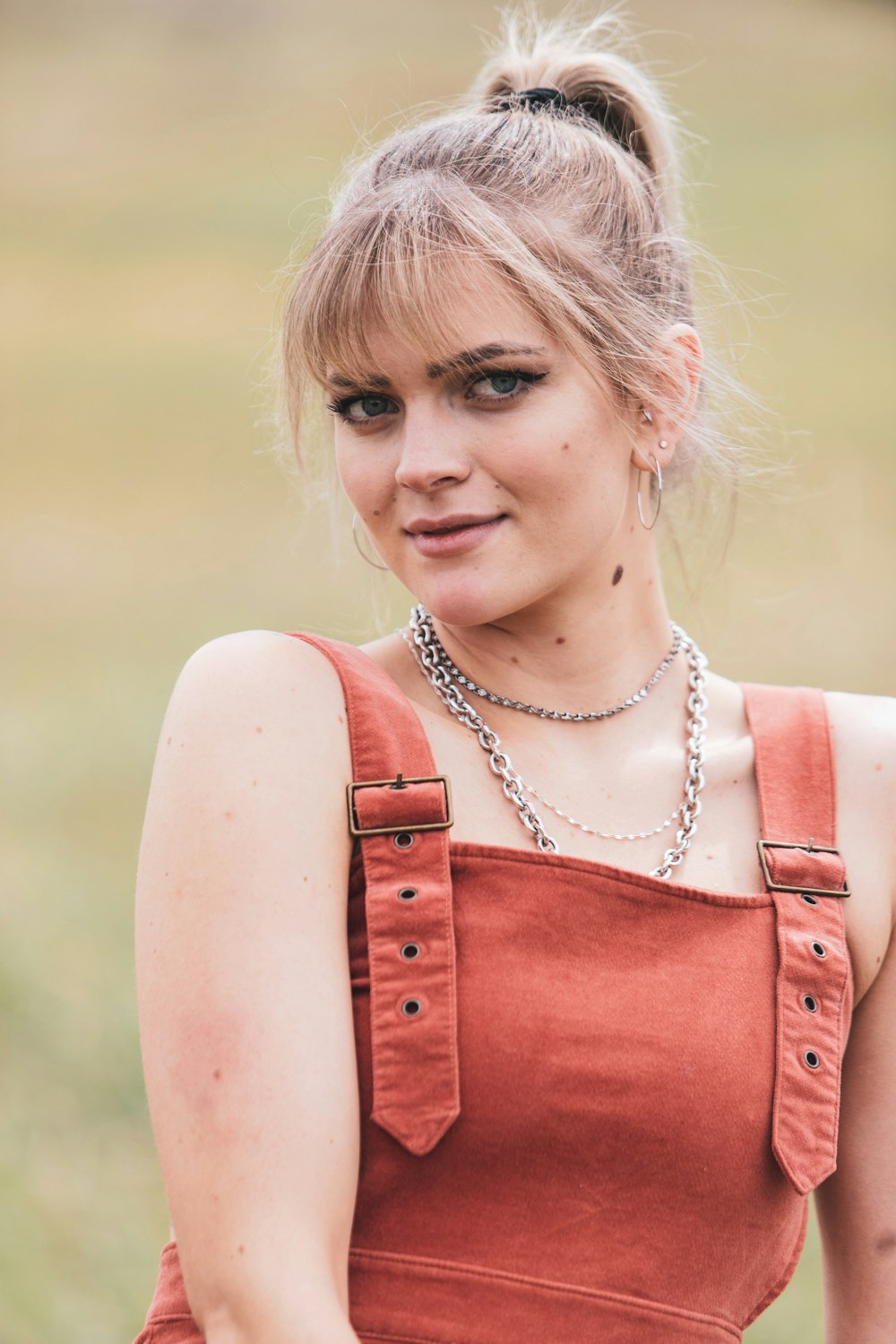 woman in red sleeveless top wearing silver necklace