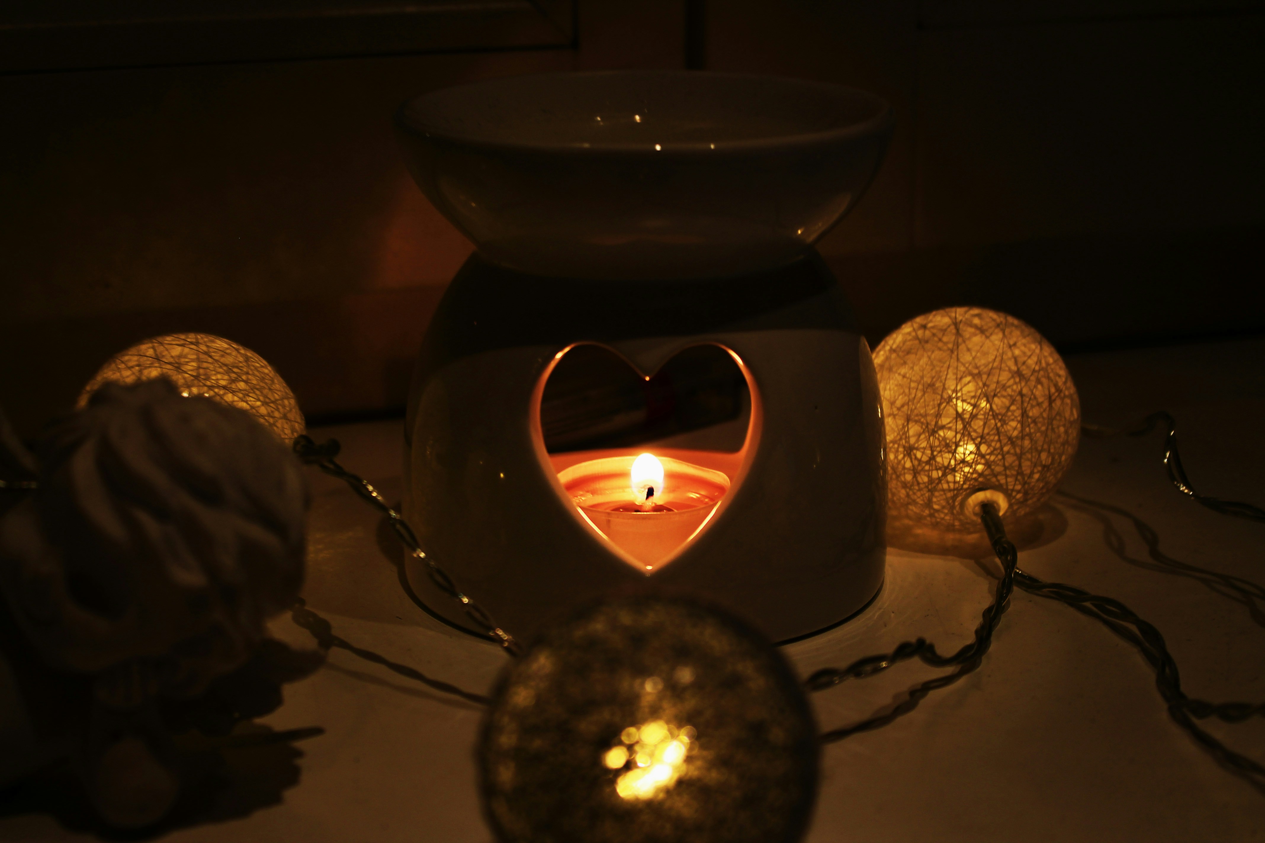 lighted candle in black ceramic candle holder