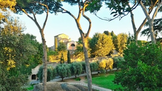 A serene landscape showcasing lush greenery and a historic building.