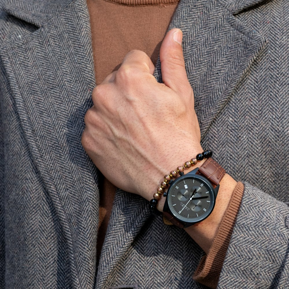 person wearing silver round analog watch