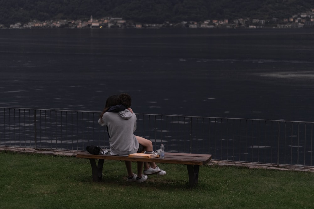 woman in white shirt sitting on brown wooden bench