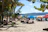 A colorful beach scene in Goa with umbrellas, palm trees, and people enjoying the sun.