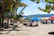 A colorful beach scene in Goa with umbrellas, palm trees, and people enjoying the sun.