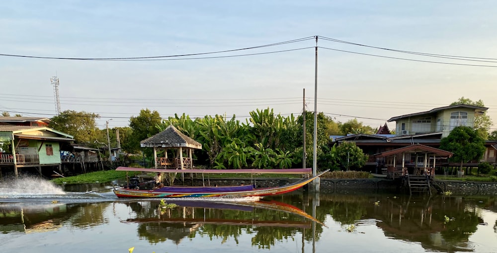 brown wooden house near green trees and body of water during daytime